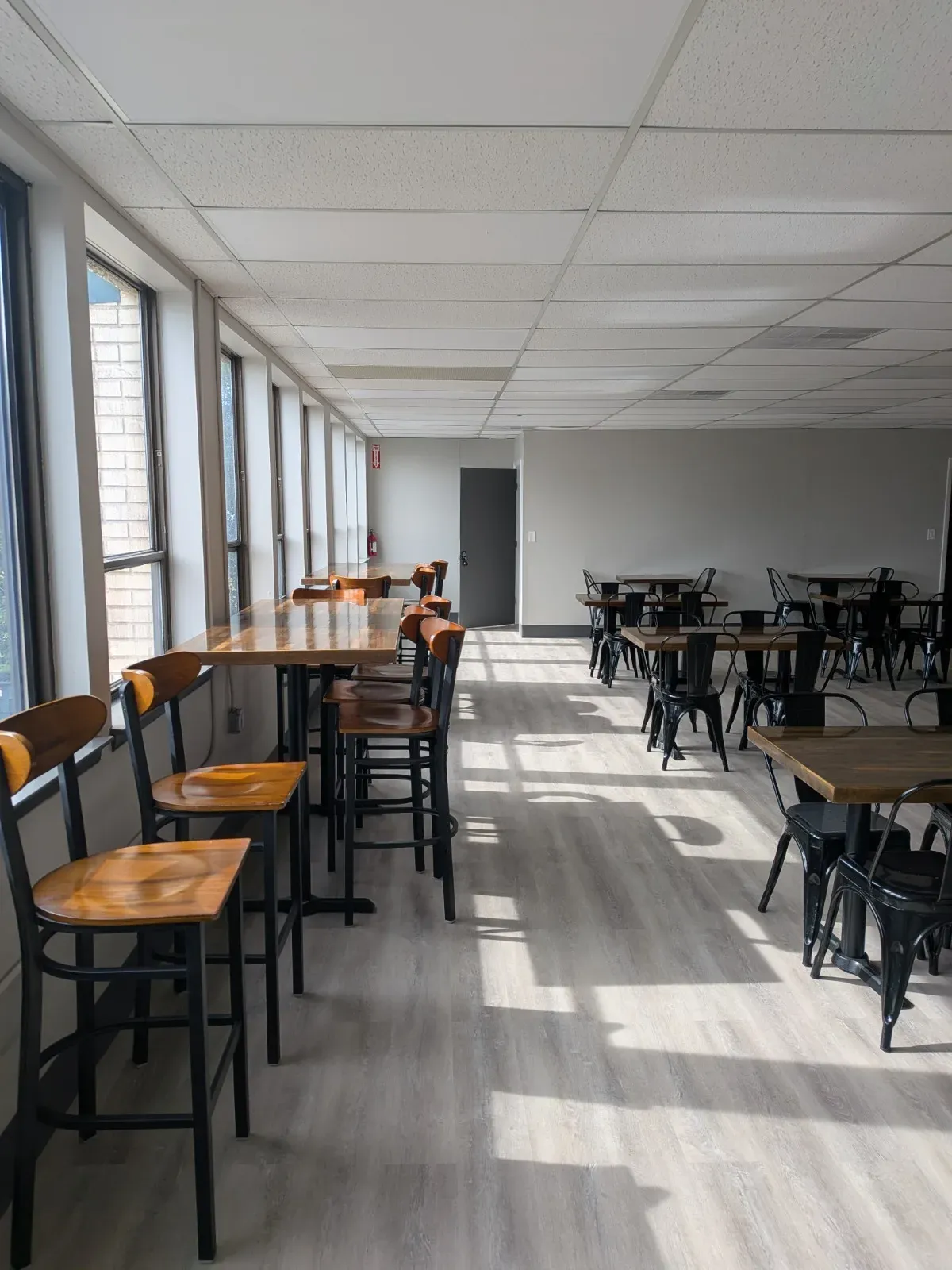 Sunlit window bar seating and tables in the MC² workspace
