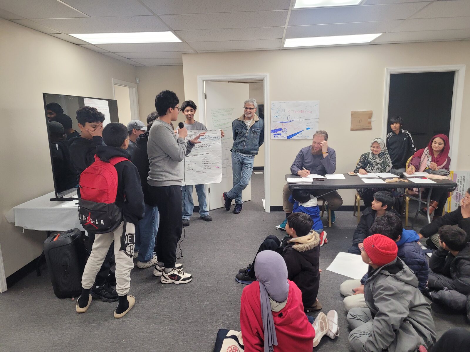 A mentor guiding young participants during a workshop session